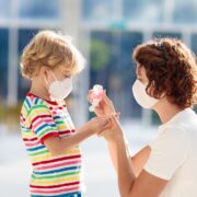 Mother and child with face mask and hand sanitizer